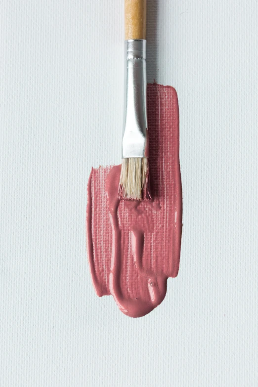 a paintbrush on a white piece of art