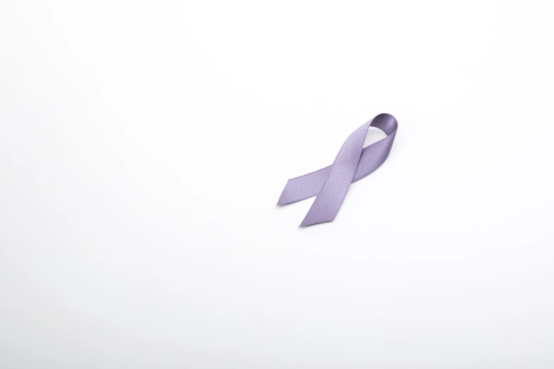a purple ribbon laying on top of a white surface