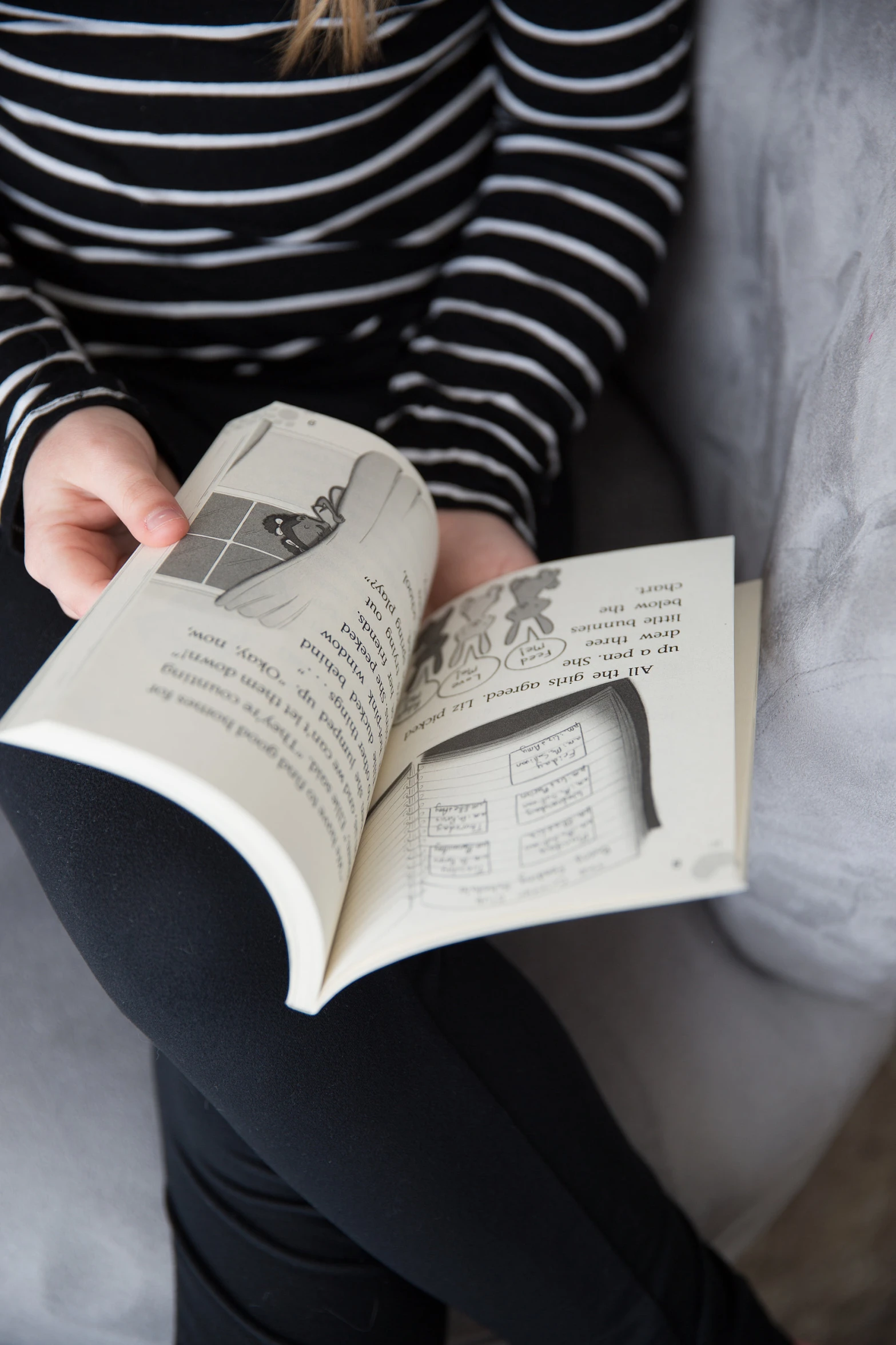 a woman reading a book while sitting down