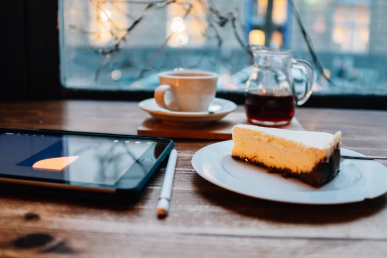 there is a tablet next to a small slice of cake