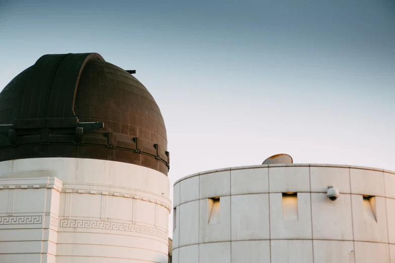 a large, circular object at the end of the top of two white towers