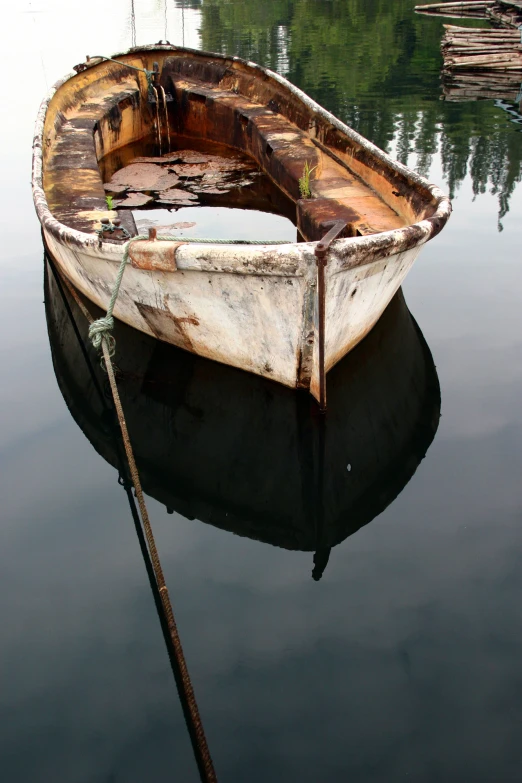 an old boat floating on a still body of water