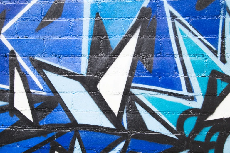 blue and black wall with graffiti on it