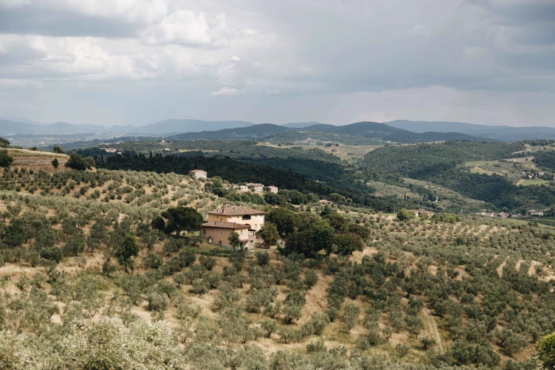 a lone house sitting on the edge of a small cliff in the countryside