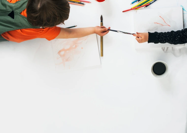 a child is drawing with crayons and pencils