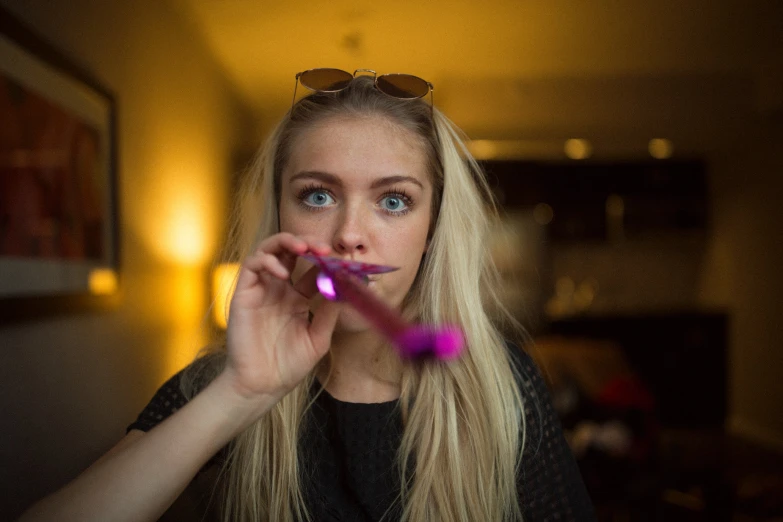 a beautiful young blonde wearing glasses making a face