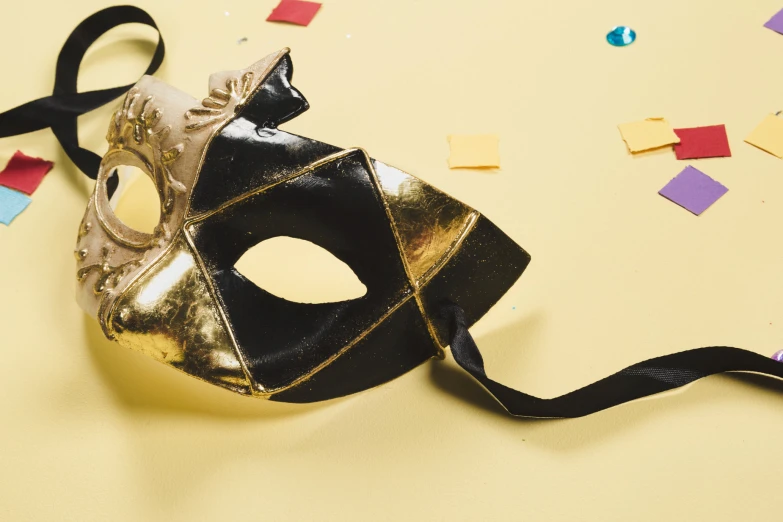 a mask laying on the ground with many confetti on it