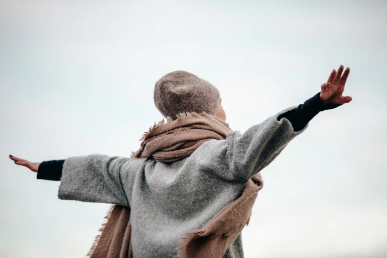 a woman with arms wide outstretched to the sky