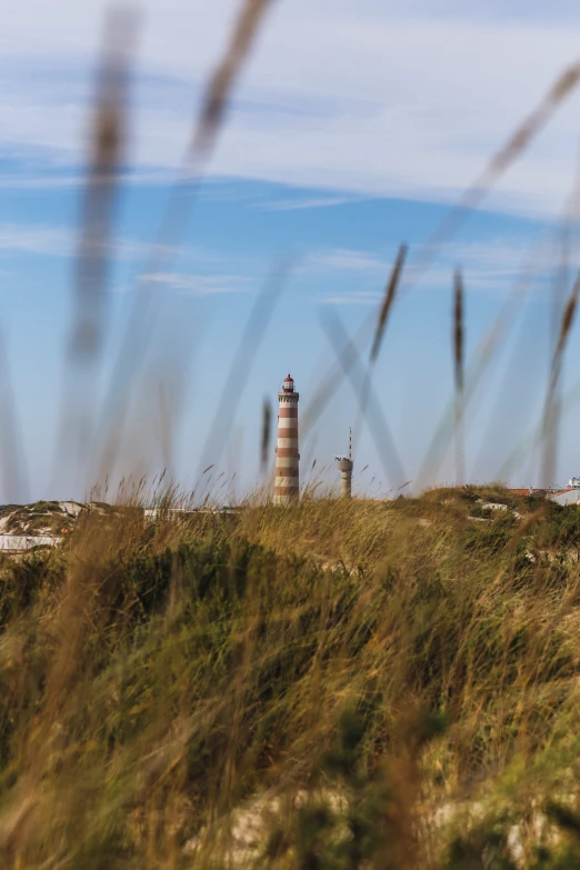 a lighthouse on a cliff in a field