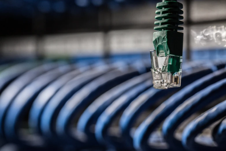 a long green ethernet cable laying on top of a blue metal rack