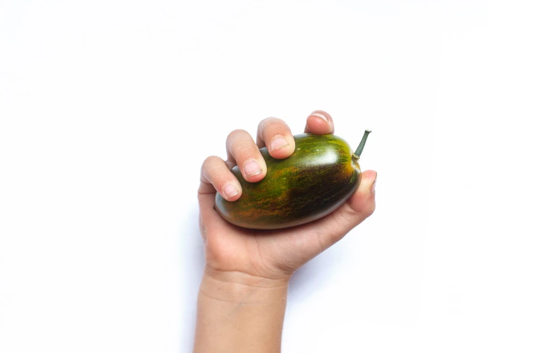 a hand holding a green apple over a white background