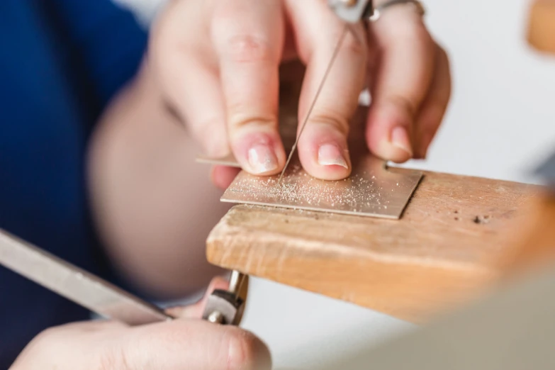 a person cuts wood with scissors on it