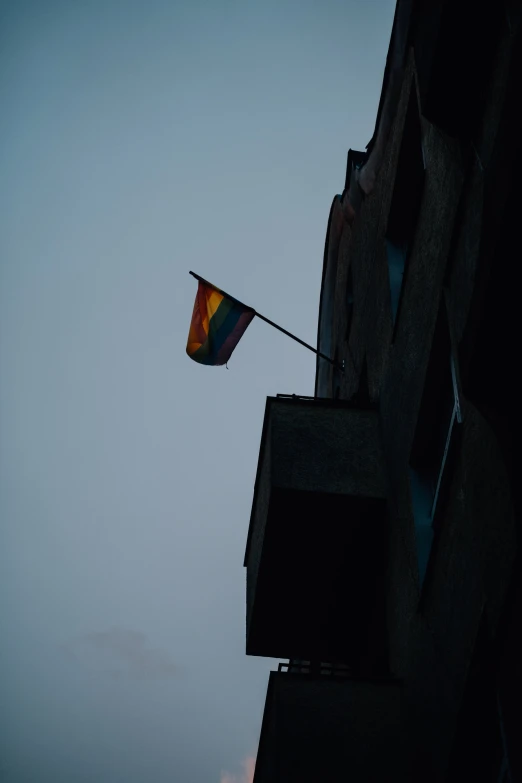 the rainbow flag is hanging from a building