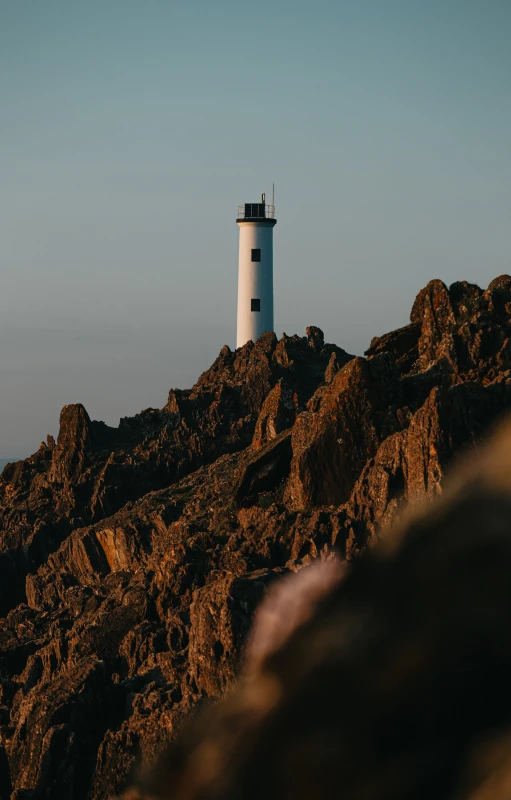 a light house on top of a rocky hill