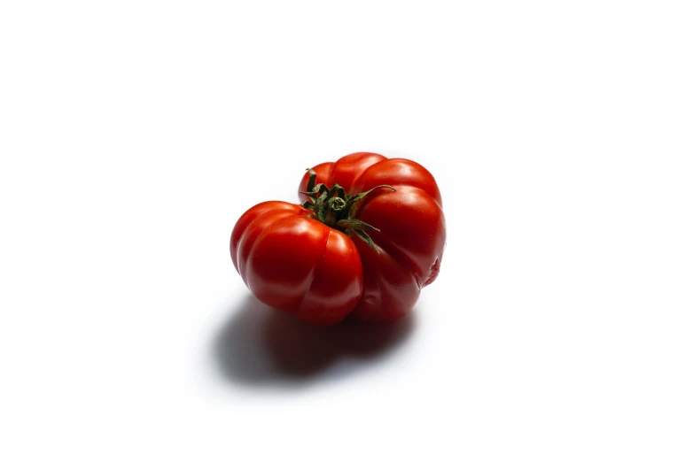 three tomatoes sitting side by side on a white surface