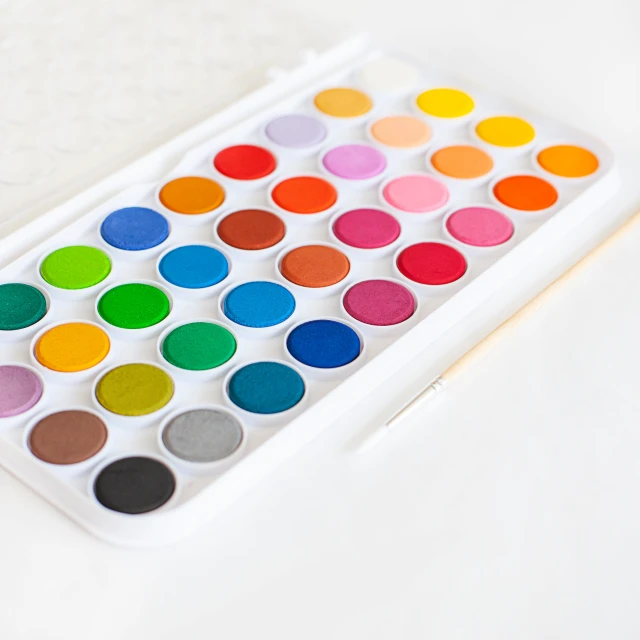 a large white tray filled with colorful water colors