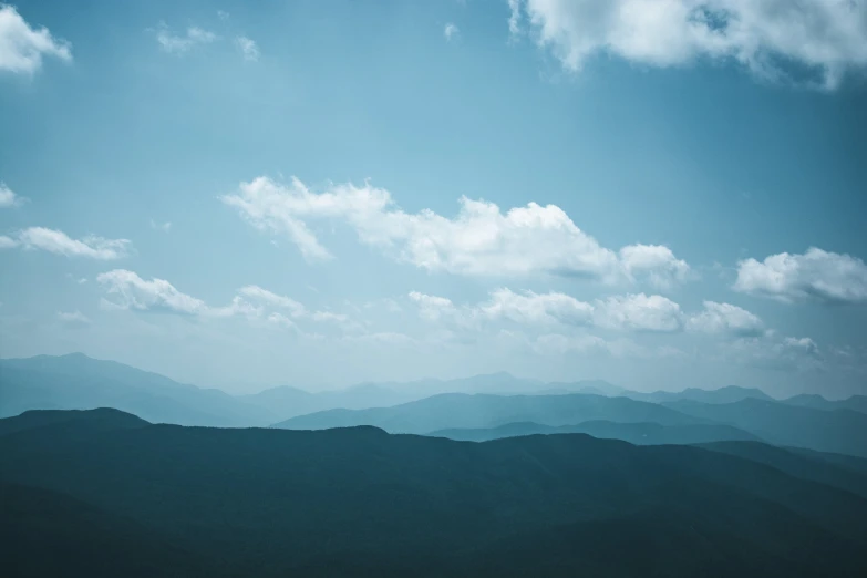 clouds moving through a blue sky over mountains