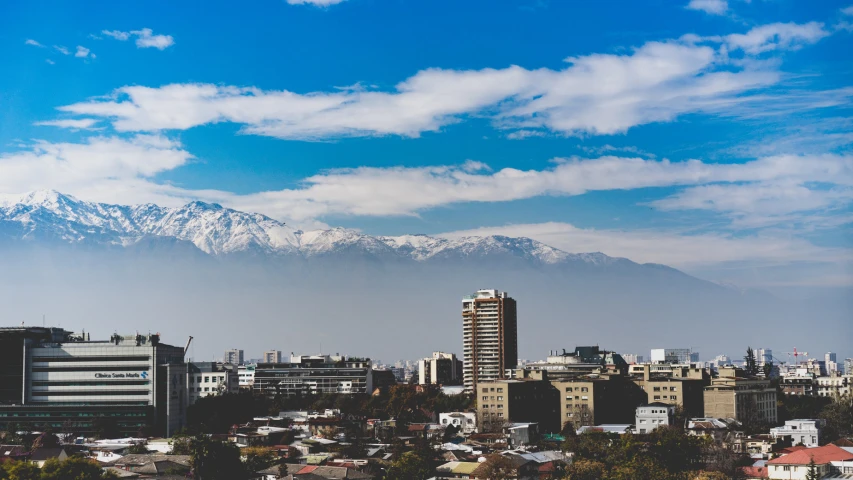 a view of a snow capped mountain from across the city