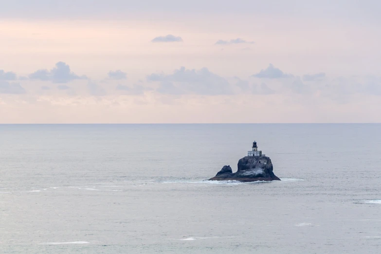 a small light house on top of an island in the middle of the ocean