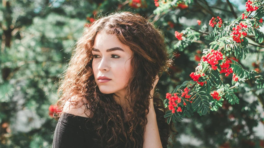 a woman in black sweater with long curly hair