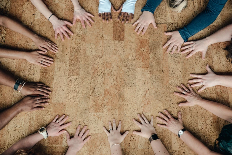 people with their hands together and a circle that is covered in dirt