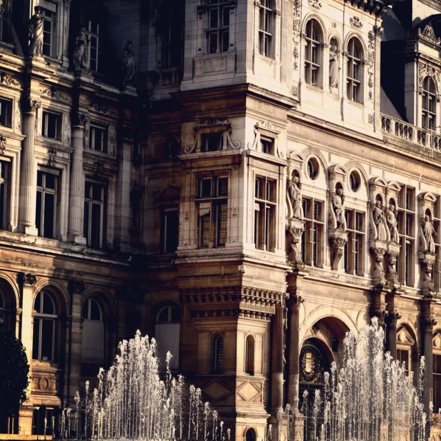 a large building with fountains outside in the day light