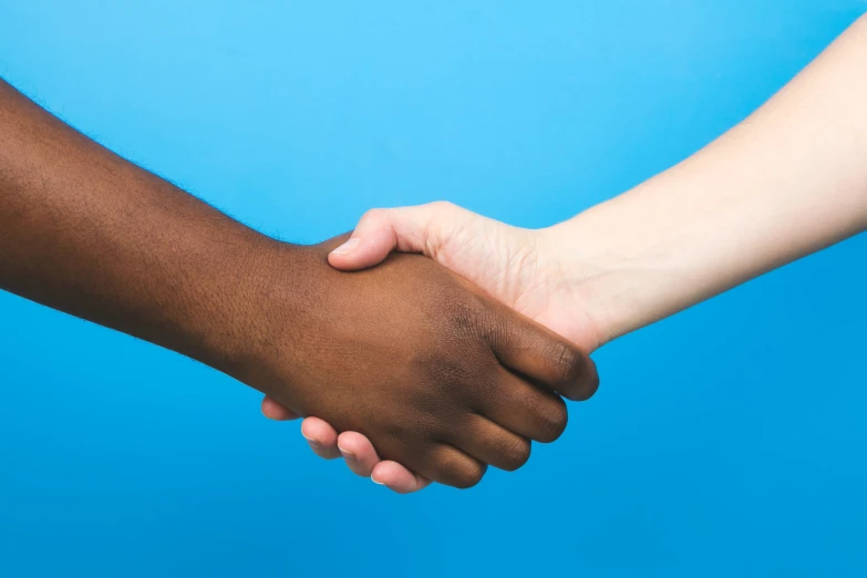 two black men hands holding each other with blue background