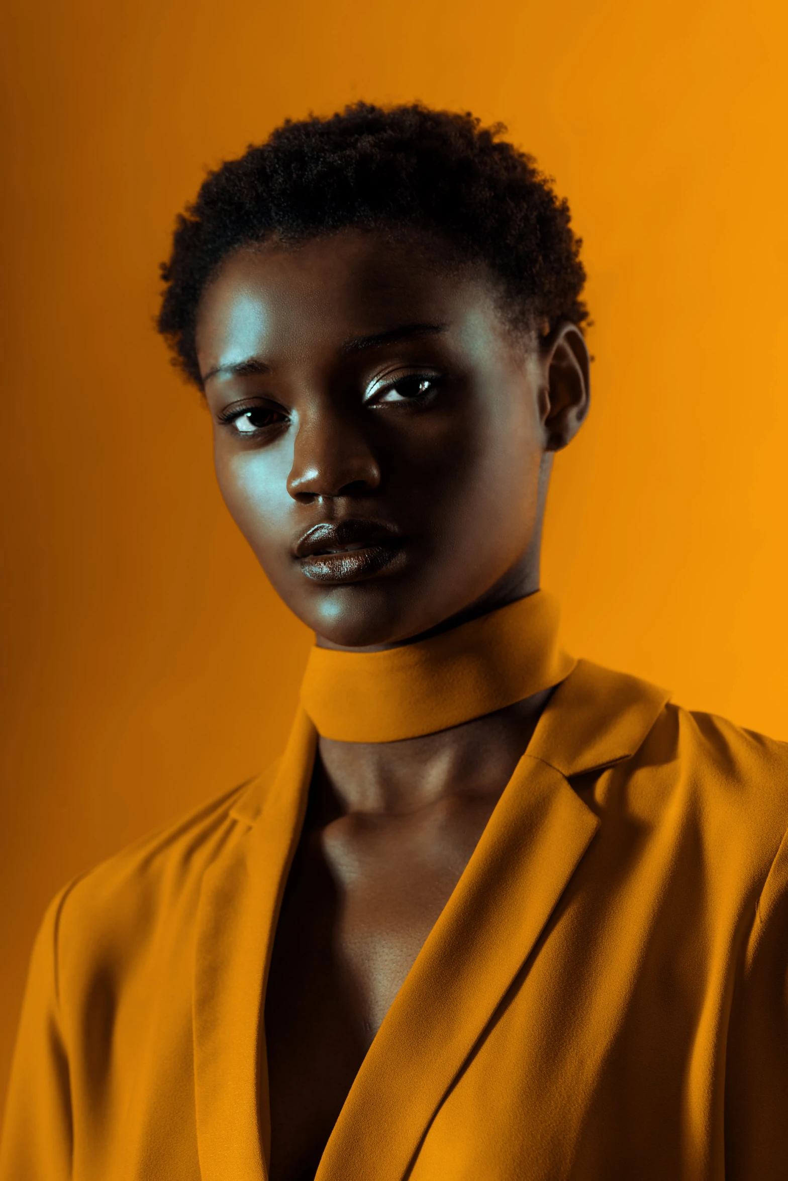 black woman posing with an orange background