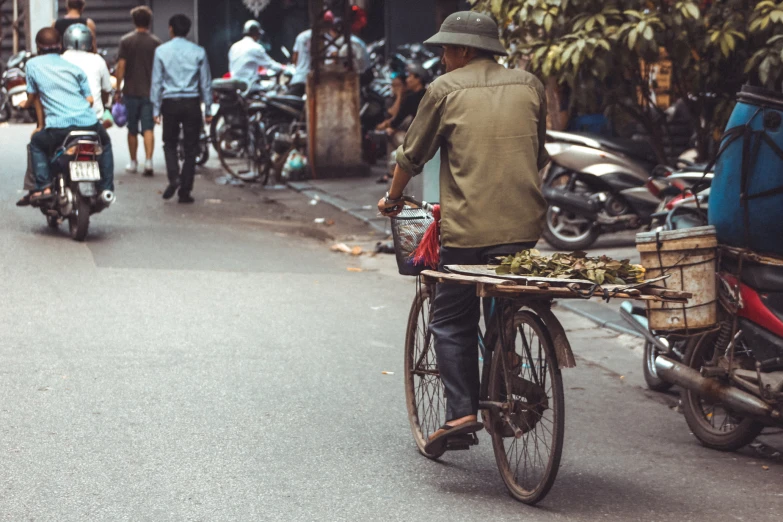 an asian man is riding his bike down the street