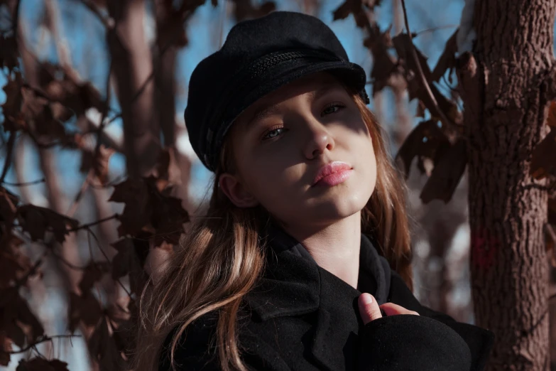 woman standing next to a tree with her lip out