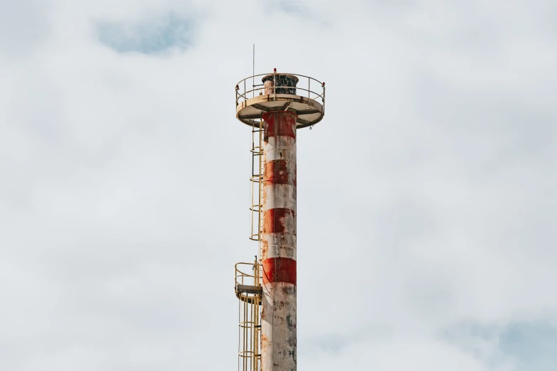 a tall metal tower under a cloudy sky