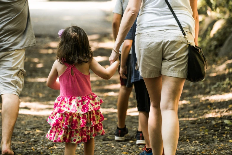 a  holds the hand of two adults and one child's hands