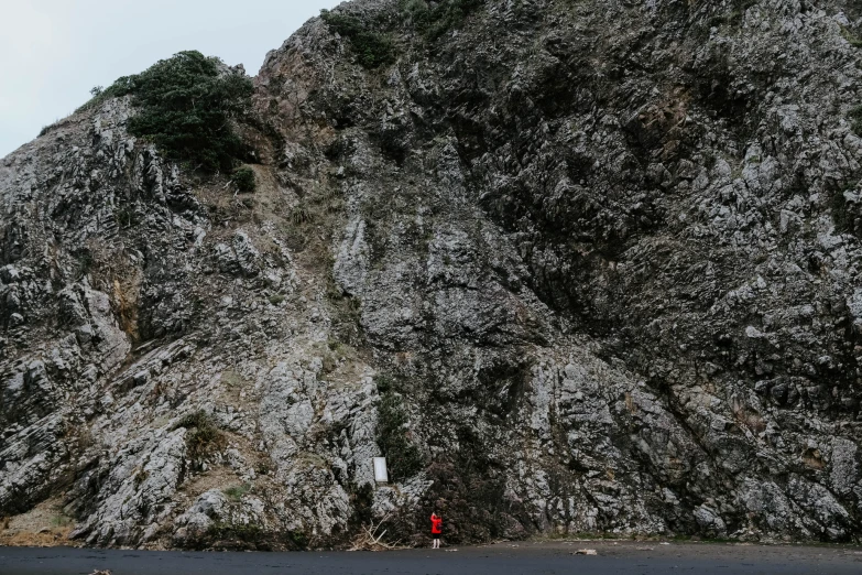 a man standing in front of a tall, rock - like mountain