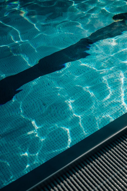 shadow in the swimming pool of a boy on a surfboard