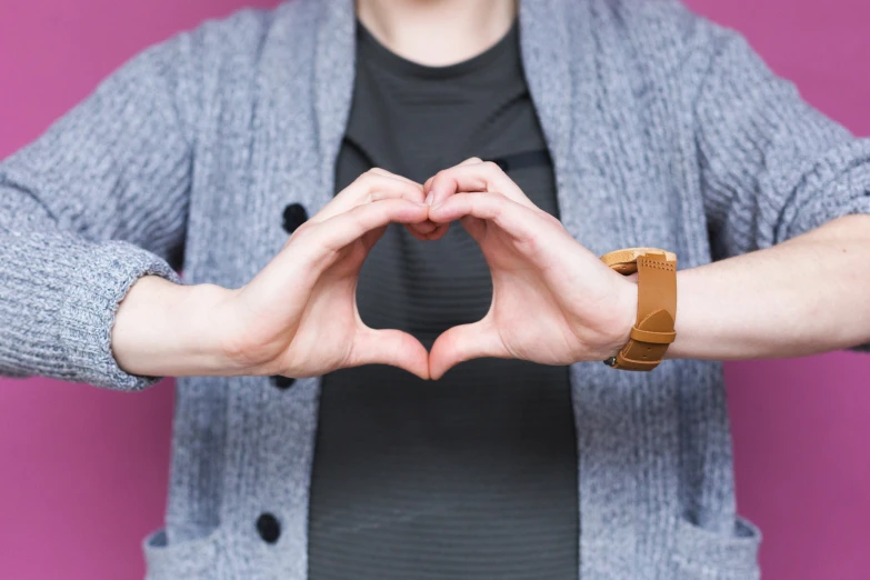 a woman making a heart with her hands