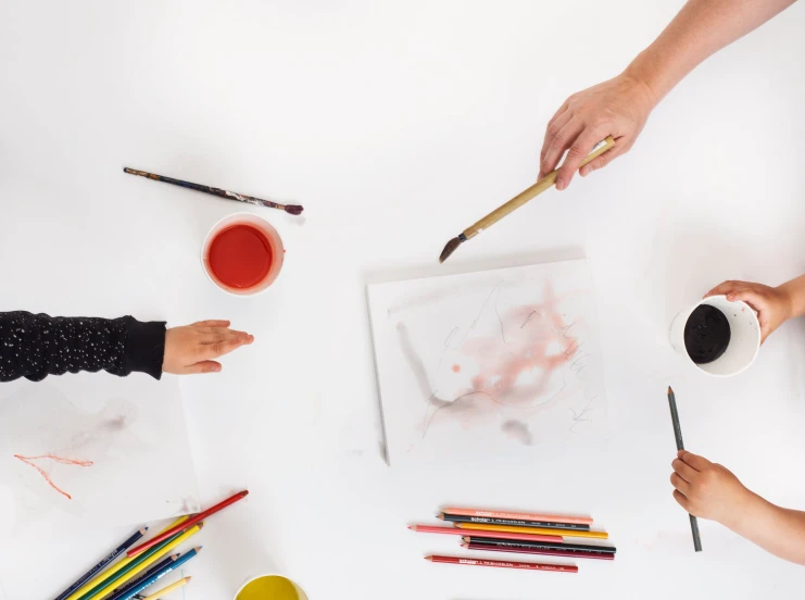 two children working on painting with paints and markers