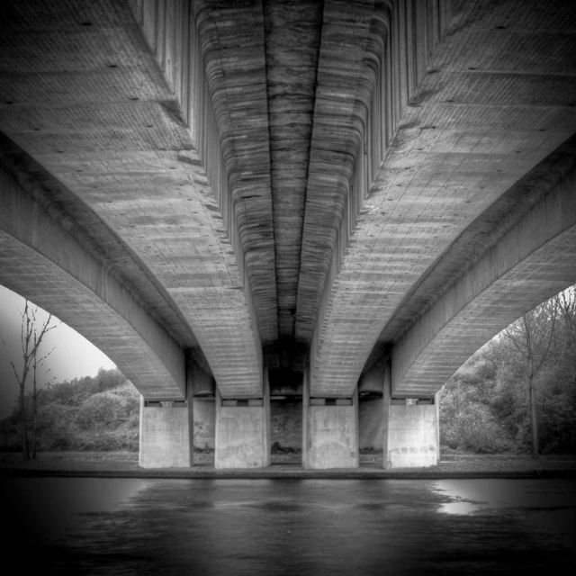 black and white pograph under bridge over water