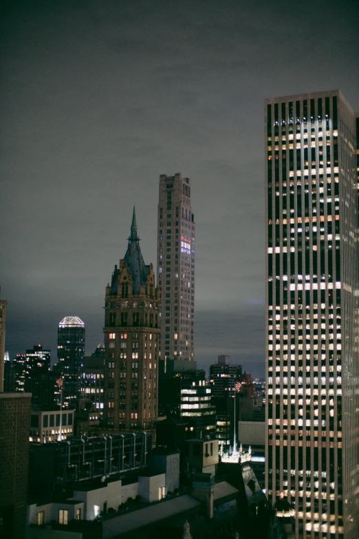 a night time city with skyscrs and the lights of their buildings in the foreground