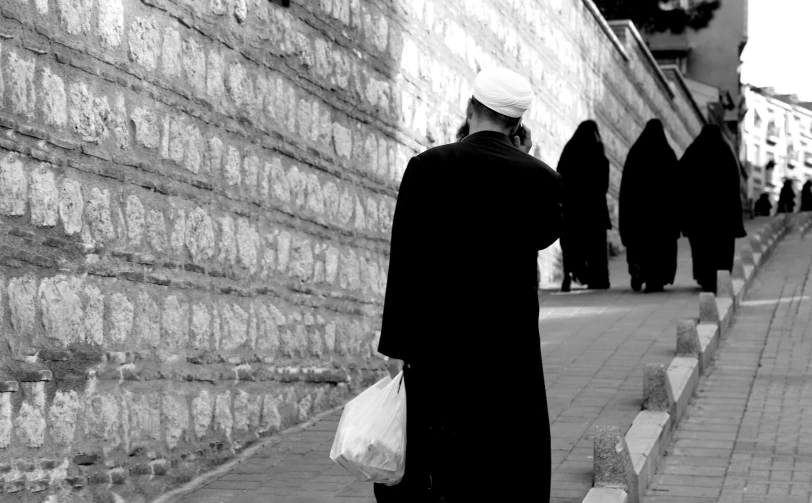 people stand in front of an old stone wall