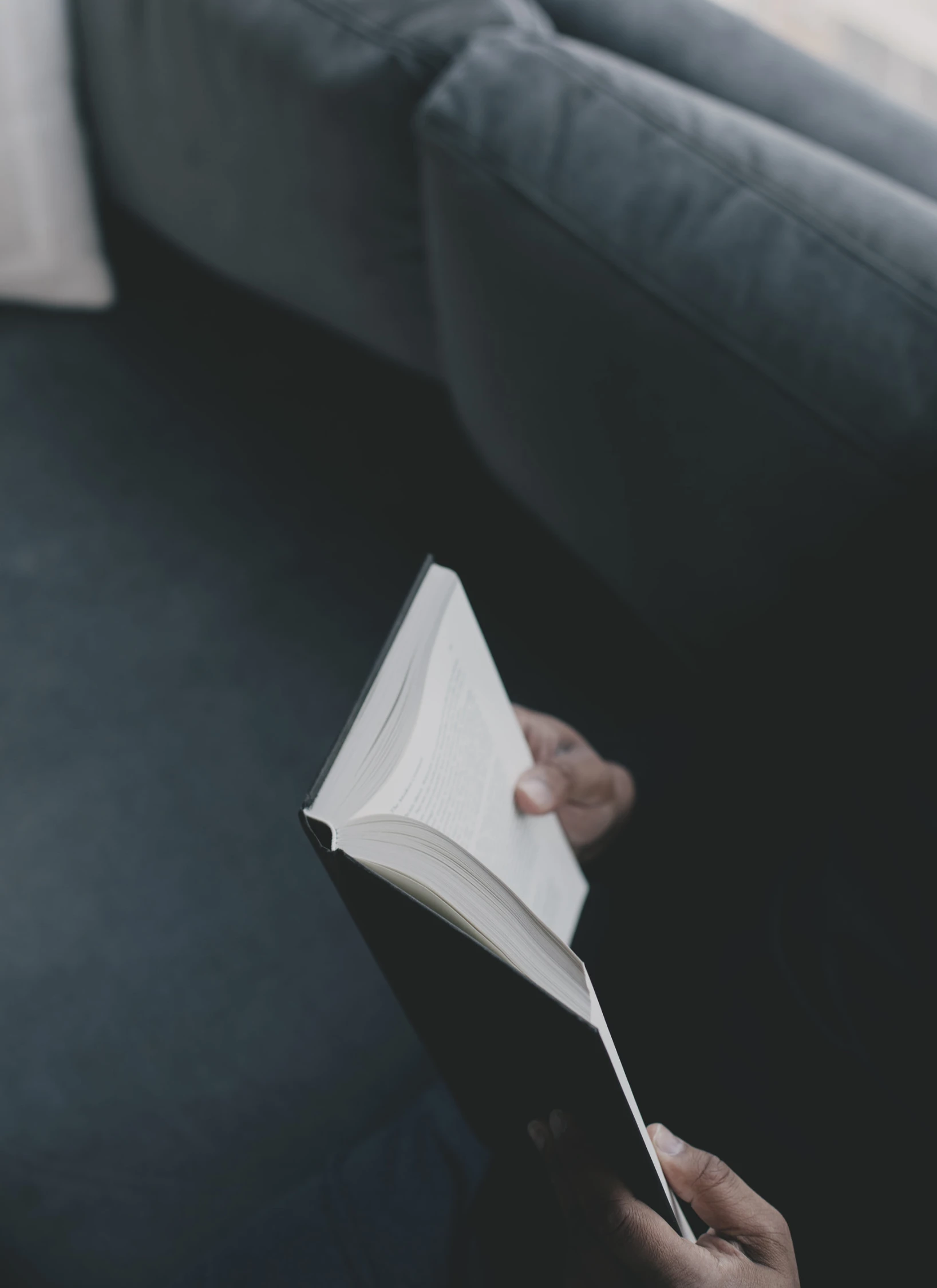 a person reading a book on a couch