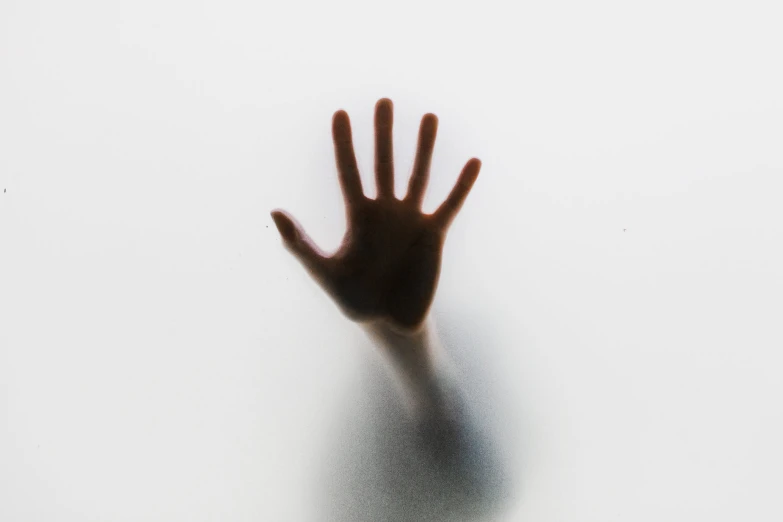 a hand reaching up with it's shadow on the wall