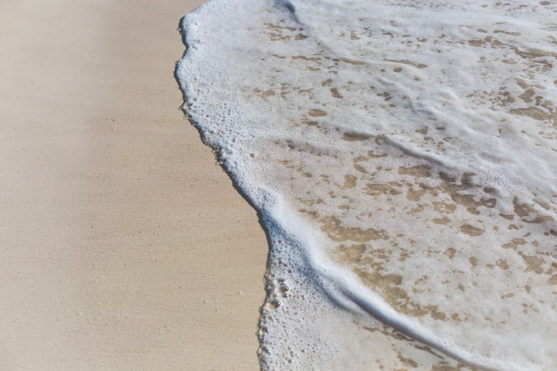 waves coming in on a sandy beach with soft sand