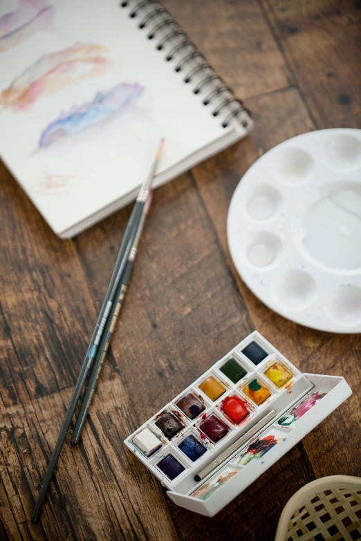 a palette, paint and a cup with paints