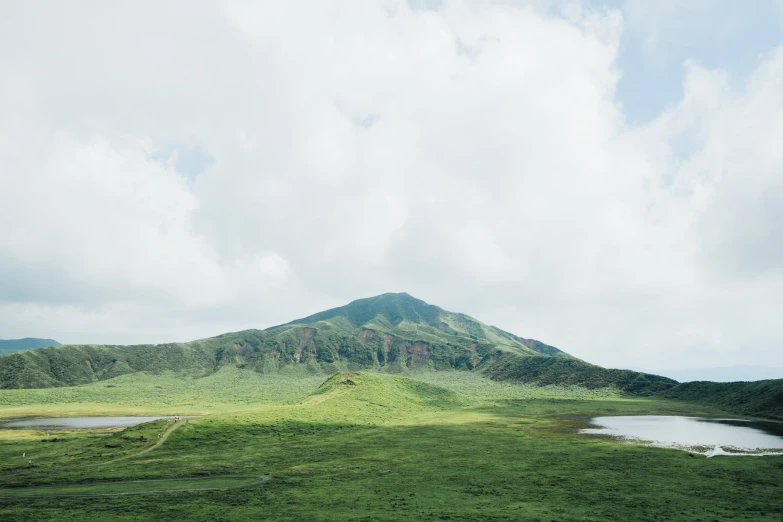 a grassy field with some hills in the background