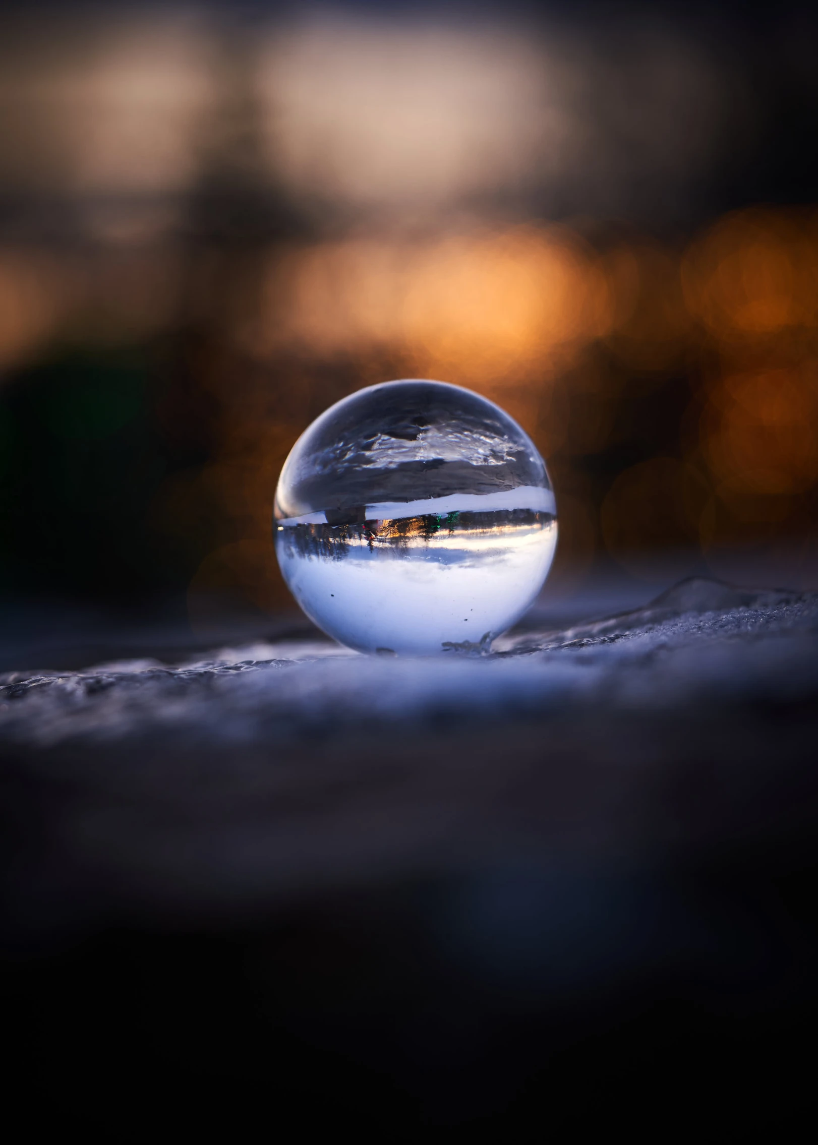 a glass ball sits on the ground and looks like it is melting