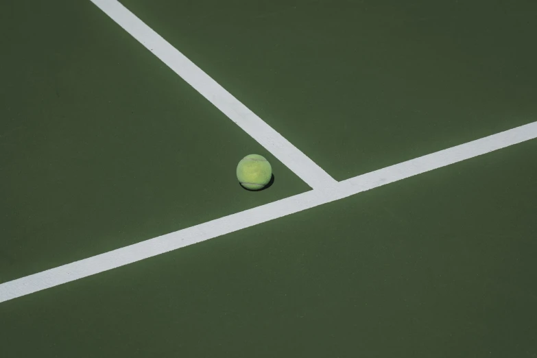 a tennis ball sits on a clay tennis court