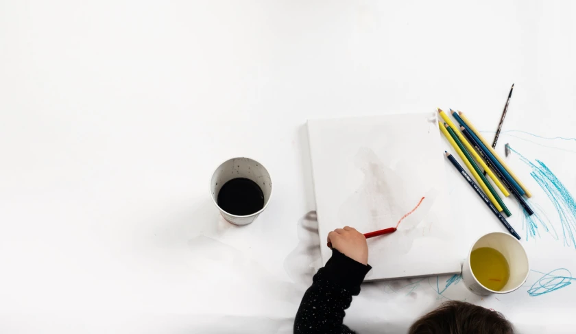 two cups and a paper on a table with two pencils