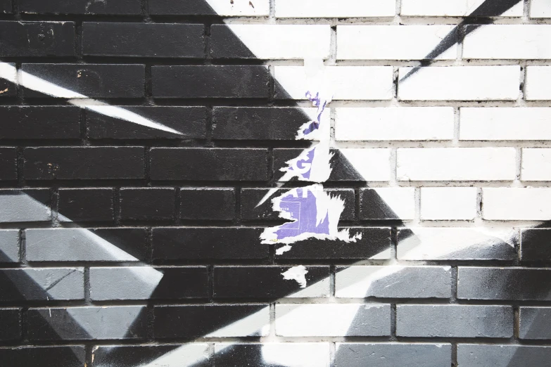 a painted white and black star on a brick wall