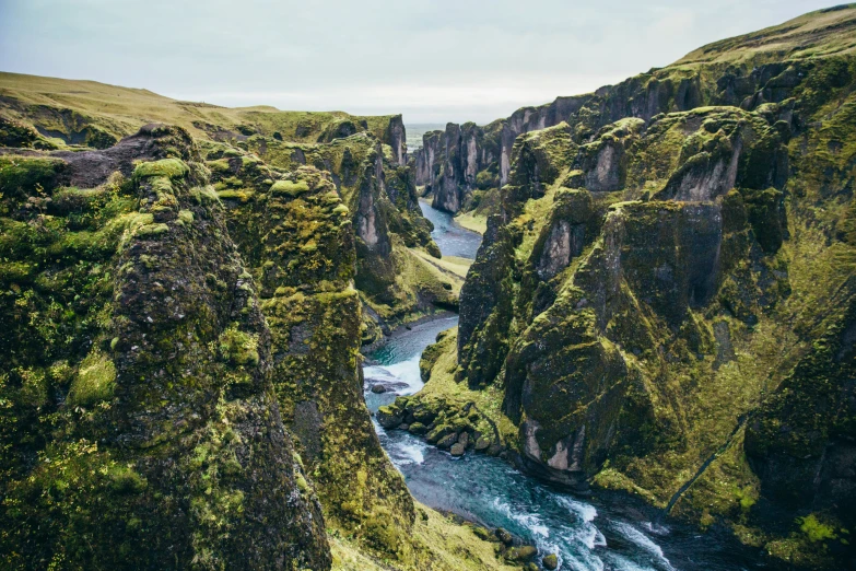 a canyon that is surrounded by lush green hills