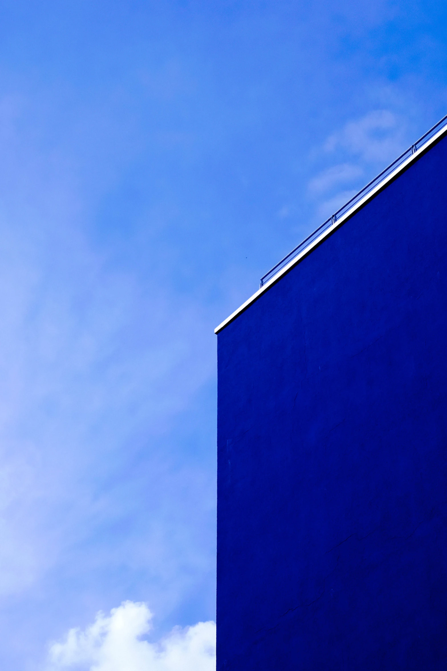 a bright blue and white tower with a plane flying in the background